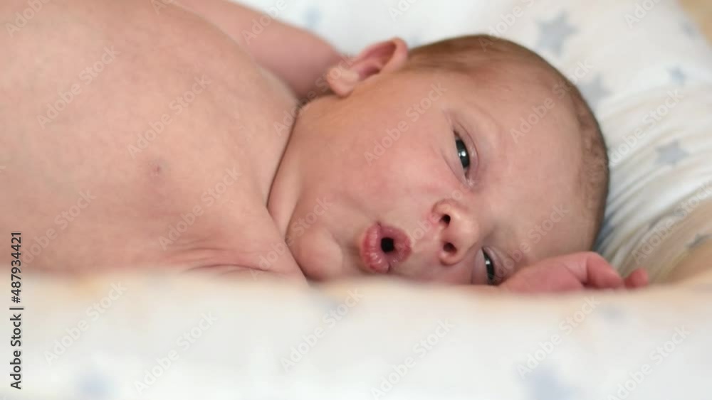 Closeup portrait of Newborn baby on white blanket. Soft focus. Infant is lying, yawning. One, two week age. Infant girl waking up on bed at home. New life and growing up concept. Real People. Closeup portrait of Newborn baby on white blanket. Soft focus. Infant is lying, yawning. One, two week age. Infant girl waking up on bed at home. New life and growing up concept. Real People.