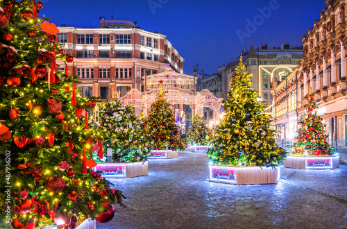 Christmas trees in toys on the Kuznetsky bridge near the Central Department Store in Moscow in the light of night lights