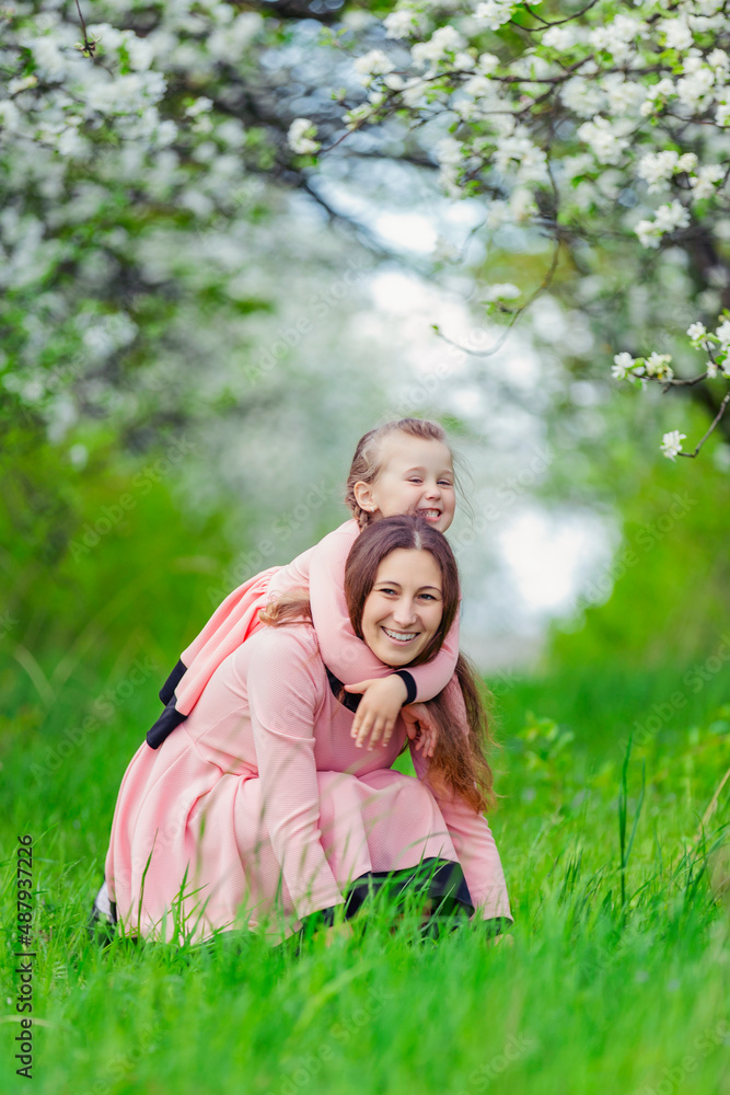 mother and daughter hugging against the backdrop of flowering trees