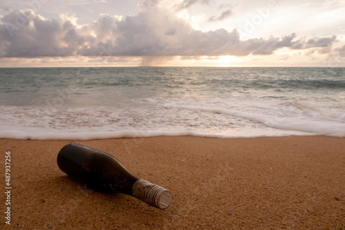 The brown bottles placed on the beach by the sea are a state of ocean waste.