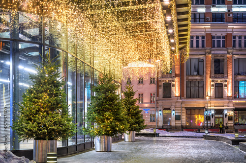 Christmas trees near the entrance to the Central Department Store in Moscow in the light of night lights