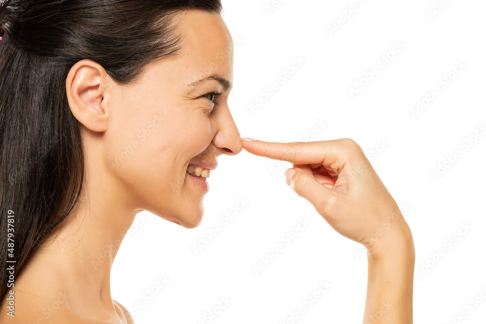 young happy woman touches her nose with her finger young happy woman touches her nose with her finger