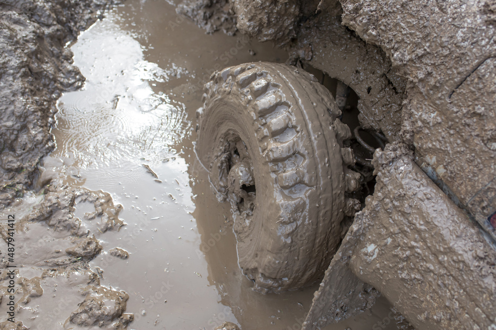 Car wheel stuck in mud, motorsport, mud tire testing. Offroad driving