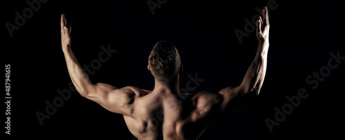 Obraz na plátně Bodybuilder man show biceps, triceps with raised hands, back