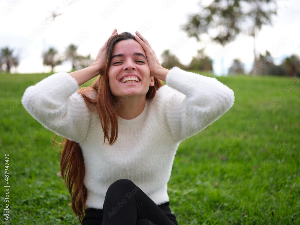 A happy young girl in the park looking at the camera having a surprise A happy young girl in the park looking at the camera having a surprise