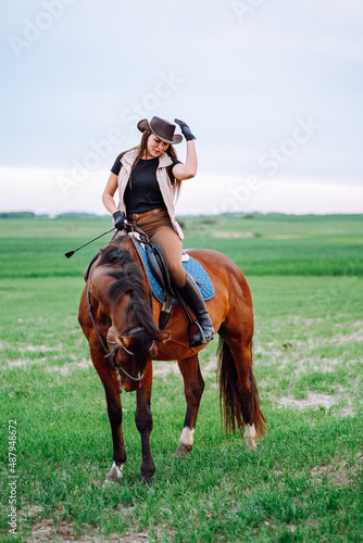 Принти на полотні Vertical confident tone horse woman hat with riding crop, look down, holding harness, whip, sport training