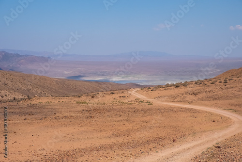 Gravel road in the mountains with sky background. Road to Bartogay reservoir from Assy plateau.