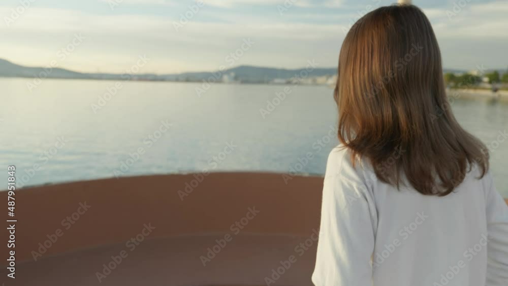 Reveal shot of a girl walking during golden hour. Flares and the setting sun shown in the end. Reveal shot of a girl walking during golden hour. Flares and the setting sun shown in the end.