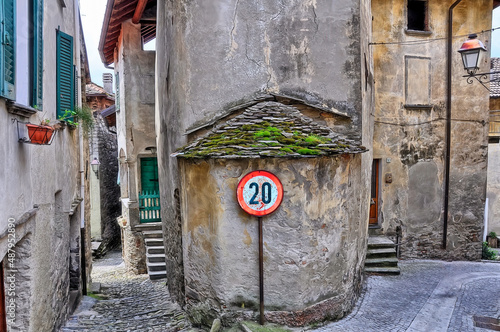 Intersección de dos callecitas medievales en un pueblo de Como (Italia) con un cartel en el centro indicando 20 km de velocidad. photo