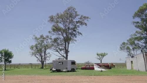 Abandoned building and cars on road near Saladas, Argentina. Pan right photo