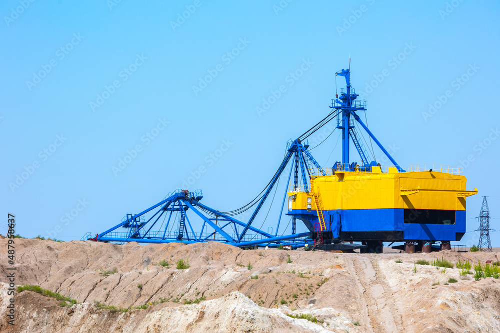 Quarry extraction porcelain clay(kaolin) and quartz sand in the open pit mine. Powerful industrial walking excavator on the site. Quarry extraction porcelain clay(kaolin) and quartz sand in the open pit mine. Powerful industrial walking excavator on the site.