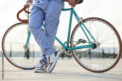 Young man with bicycle on embankment