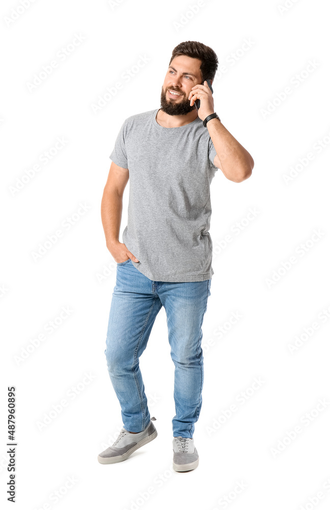 Handsome man in grey t-shirt talking by mobile phone on white background Handsome man in grey t-shirt talking by mobile phone on white background
