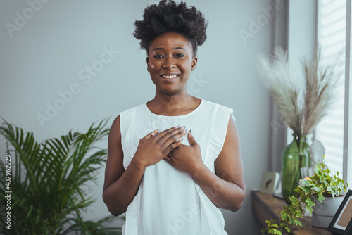 Фотография Cropped close up smiling grateful woman holding folded hands on chest, thankful