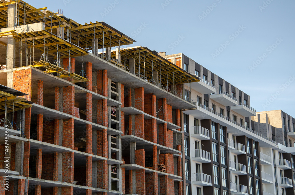 Construction site background. Hoisting cranes and new multi-storey buildings. Industrial background. brick building. Construction site background. Hoisting cranes and new multi-storey buildings. Industrial background. brick building.
