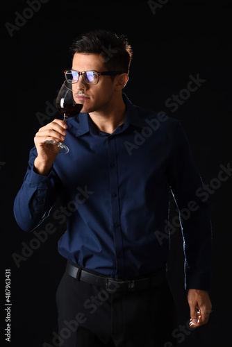 Young male sommelier tastin...