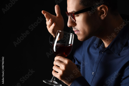 Young male sommelier tastin...