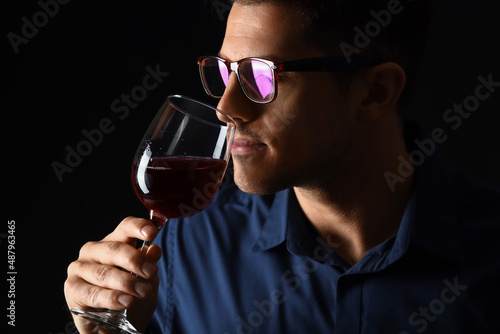 Young male sommelier tastin...
