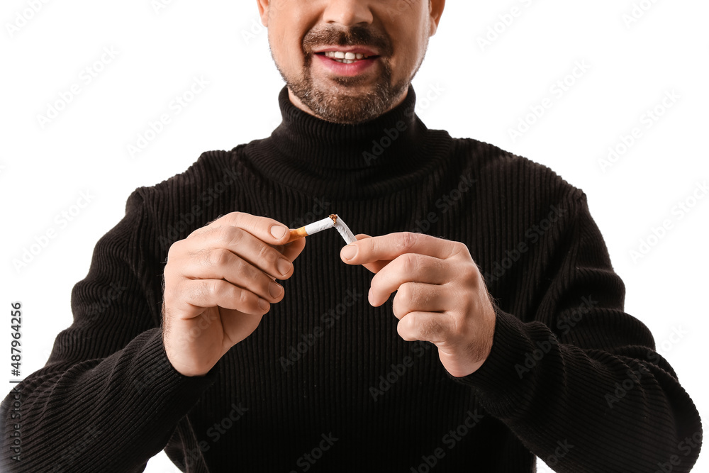 Fototapeta premium Man with broken cigarette on white background. Concept of refusing from bad habit