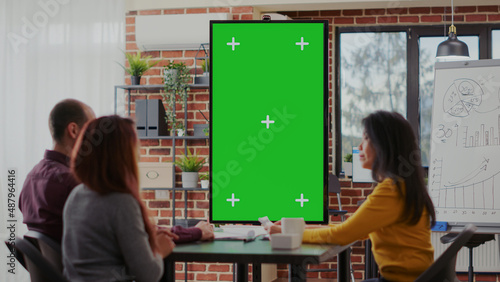 Employees using green screen on monitor vertically in boardroom, meeting to discuss ideas. Business people working with isolated mockup template and blank copy space for chroma key background.
