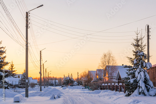 Village street with electric poles in winter