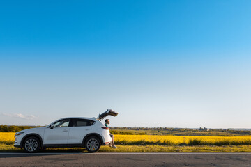 man sitting in car trunk enjoying view of sunset