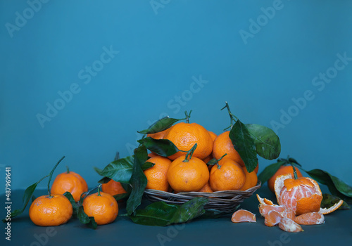 Fragrant citrus fruits on a bright background. Equipped with leaves on a colored background. The smell of christmas, alphabet of vitamins. Poster in a cafe or restaurant. Artistic view of fruit