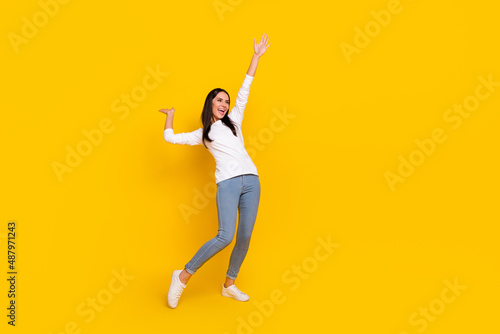 Full size photo of young cheerful woman have fun hang-out look empty space isolated over yellow color background