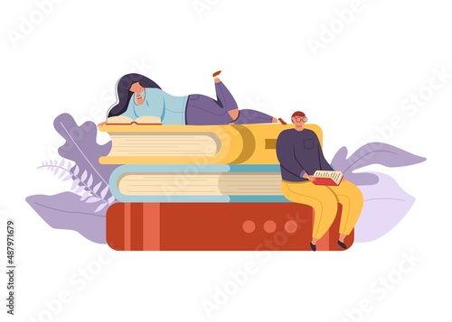 Young stylish man and woman are sitting and lying on a stack of giant books and reading.