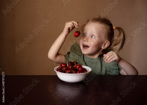 girl eating cherries at the table