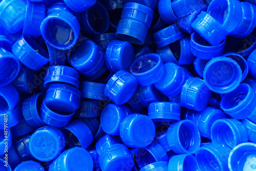 Blue plastic caps used to seal beverage bottles.