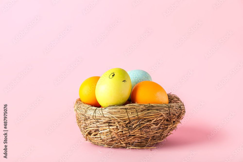 Nest with funny Easter eggs on color background Nest with funny Easter eggs on color background