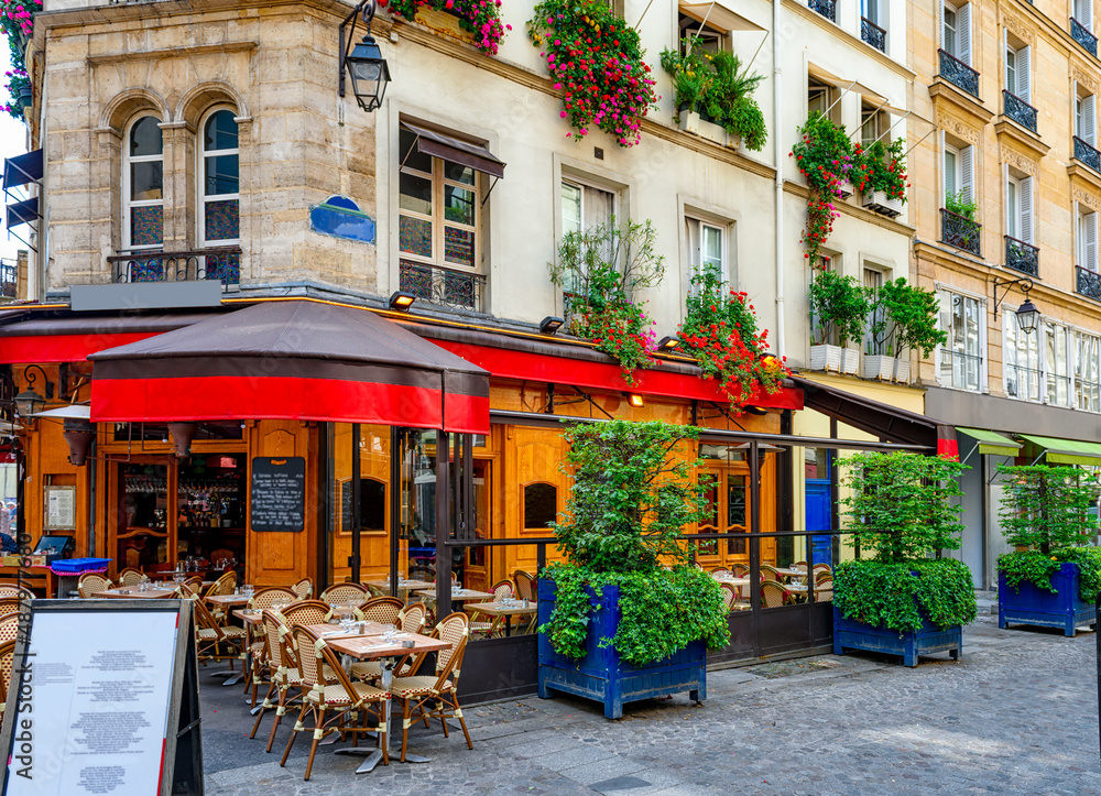 Fototapeta premium Typical view of the Parisian street with tables with tables of cafe in Paris, France. Architecture and landmark of Paris. Cozy Paris cityscape
