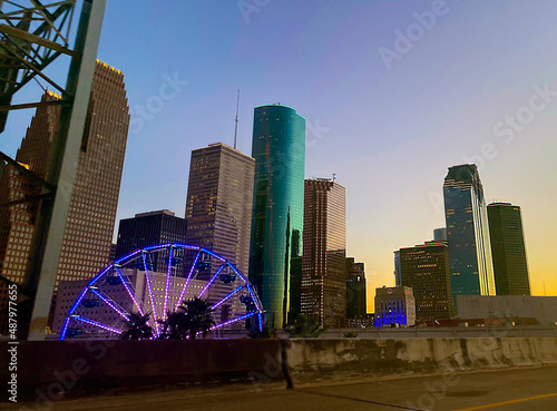Wideshot downtown Houston skyline and ferris wheel lit up at dusk, vibrant sunset and buildings