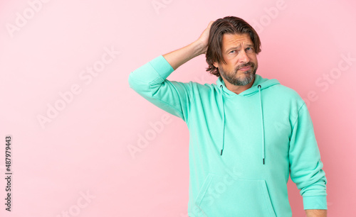 Senior dutch man isolated on pink background with an expression of frustration and not understanding © luismolinero