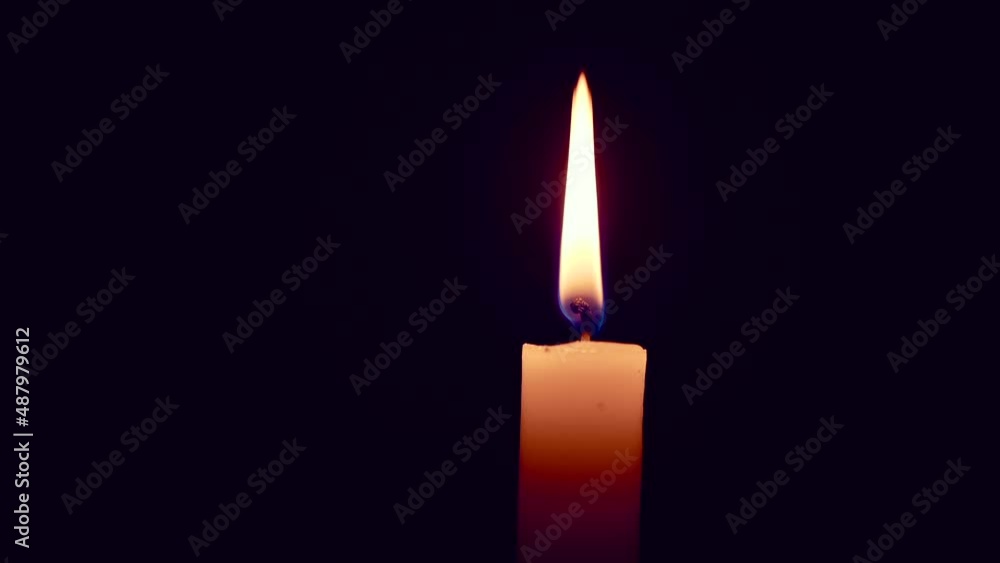 Single lit candle with quite flame on black background, blow on the flame, gust of wind Single lit candle with quite flame on black background, blow on the flame, gust of wind