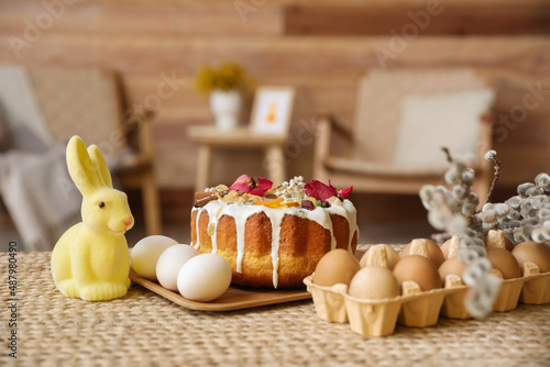 Easter cake, holder with eggs, rabbit and pussy willow branches on table © Pixel-Shot