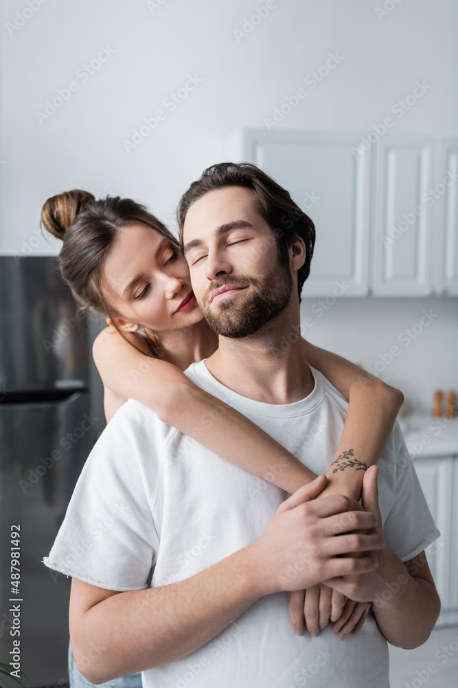 tattooed young woman hugging bearded man in white t-shirt. tattooed young woman hugging bearded man in white t-shirt.
