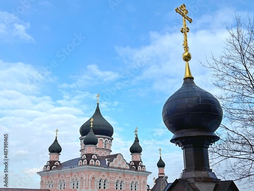 Majestic orthodox Church of Intercession of Holy Virgin in ancient Pokrov convent Monastery in Kiev city. Domes with golden crosses against blue cloudy heaven. Faith, worship, spirituality, religion. photo