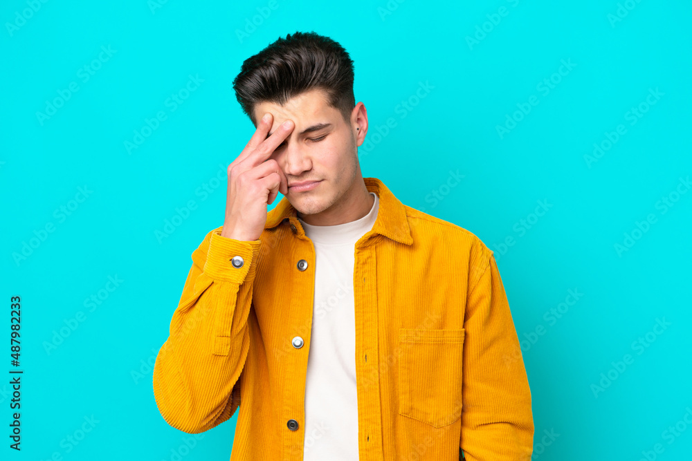 Young handsome caucasian man isolated on blue bakcground with headache Young handsome caucasian man isolated on blue bakcground with headache