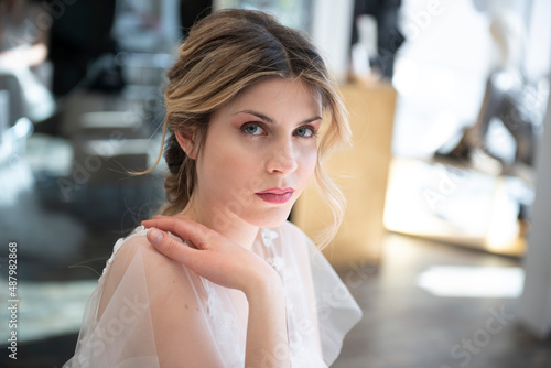 bellissima modella con acconciatura e in abito da sposa con capelli biondi e occhi azzurri photo