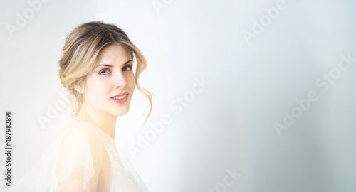 bellissima modella con acconciatura e in abito da sposa con capelli biondi e occhi azzurri photo
