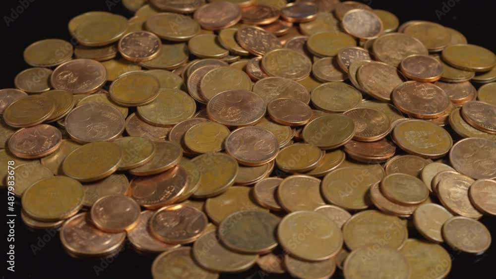 One, two and five euro cent coins rotating on a black background. European Union money and currency.