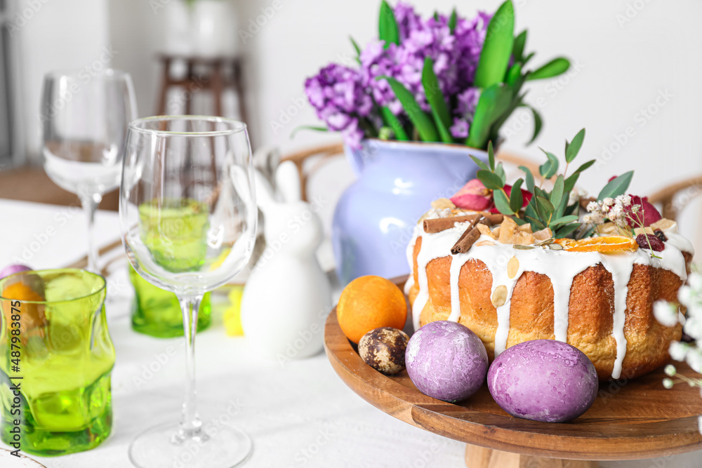 Stand with Easter cake and eggs on served table, closeup