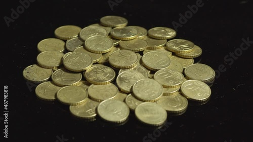 Ten euro cent coins rotating on a black background. European Union money and currency.