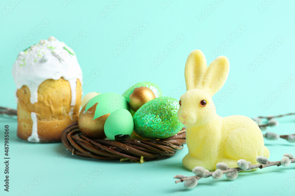 Cute Easter bunny, cake and nest with painted eggs on turquoise background