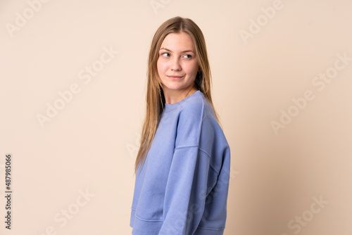 Teenager Ukrainian girl isolated on beige background . Portrait © luismolinero
