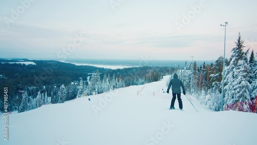 Man skiing down the slope at sunset photo