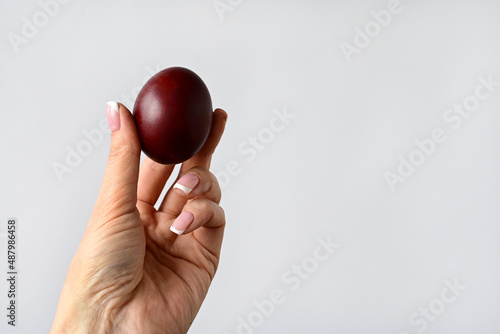 woman's hand holds an Easter colored egg isolated on a white background. Space for text