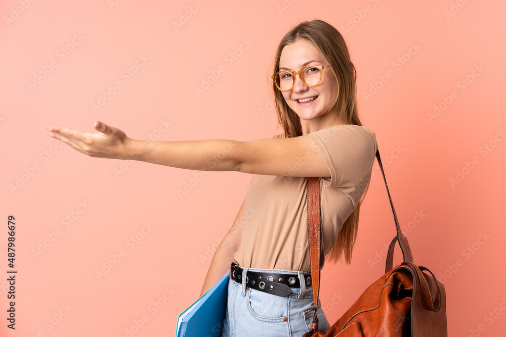 Teenager Ukrainian student girl isolated on pink background extending hands to the side for inviting to come Teenager Ukrainian student girl isolated on pink background extending hands to the side for inviting to come